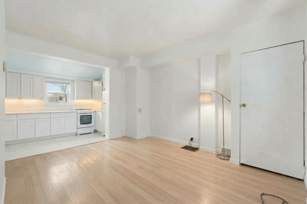 Kitchen with white cabinetry, under-cabinet lighting, gas range and a window above the counter